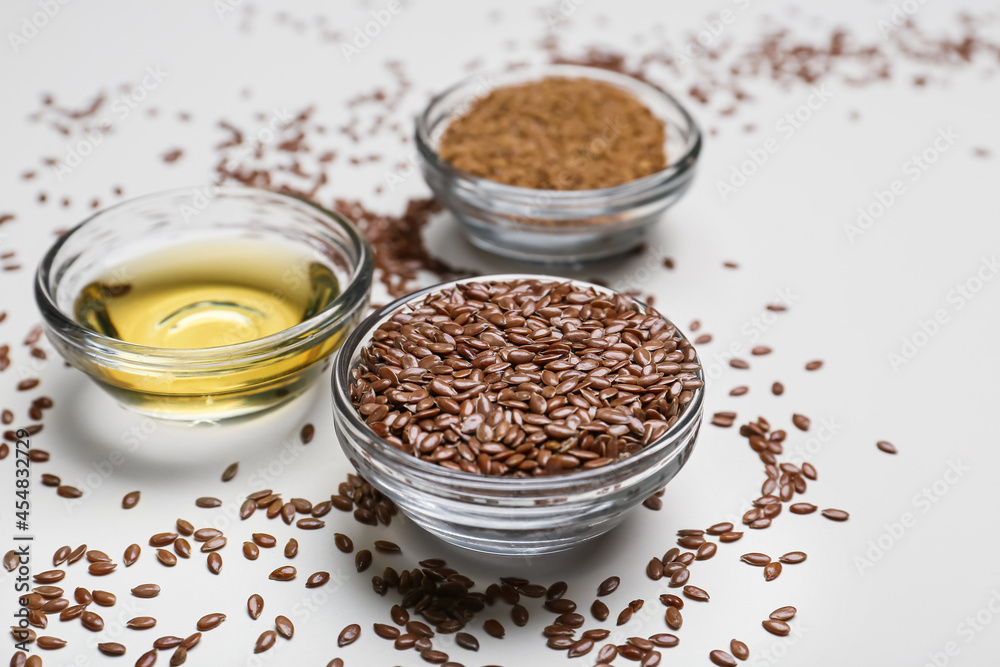 Bowls with flax seeds and oil on light background, closeup Bowls with flax seeds and oil on light background, closeup