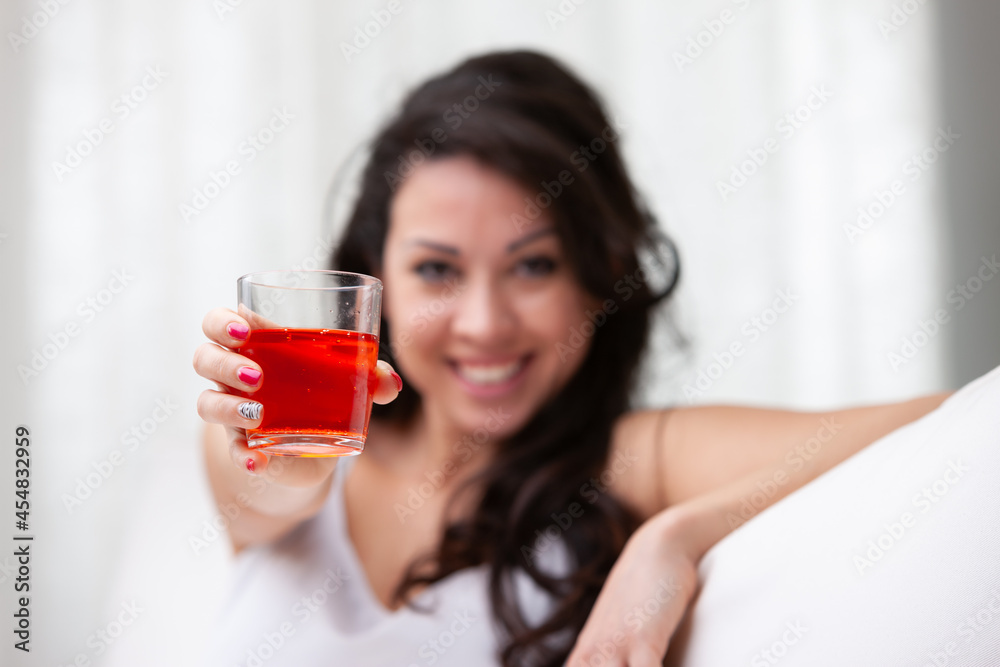 Young woman raising her glass in a toast to the viewer