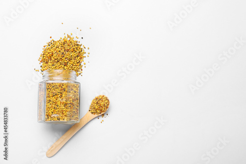 Jar and spoon with bee pollen on light background photo