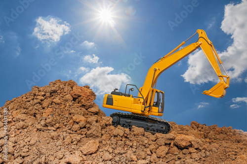 Excavator digging the soil In the construction site area on blue sky and sunlight background