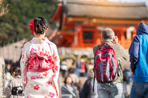 young woman tourist wearing kimono enjoying with colorful leaves in temple, Kyoto, Japan. Asian girl with hair style in traditional Japanese clothes in Autumn foliage season