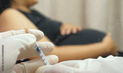 Fotografi doctor injects vaccine into pregnant woman