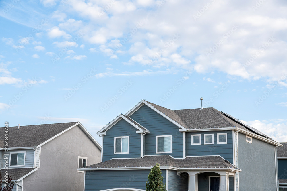 Low angle view of two-storey houses with gray and blue sidings Low angle view of two-storey houses with gray and blue sidings