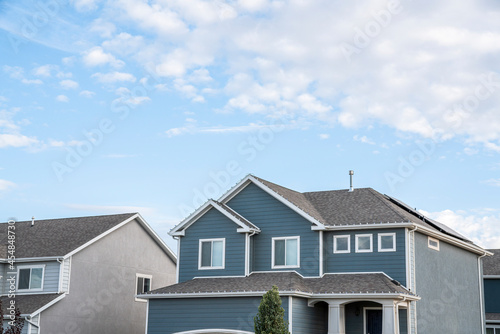 Low angle view of two-storey houses with gray and blue sidings © Jason