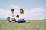 空と芝生に座る家族・ファミリー（4人）
