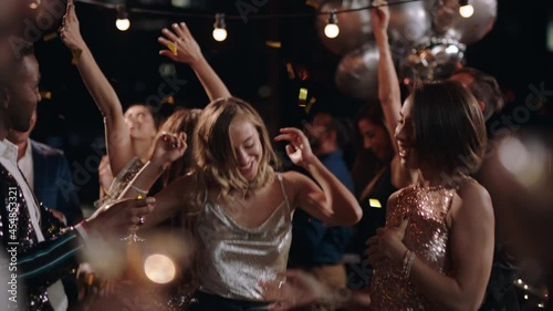 happy group of friends celebrating new years eve party dancing throwing confetti enjoying glamorous celebration wearing stylish fashion social gathering on rooftop at night 4k 