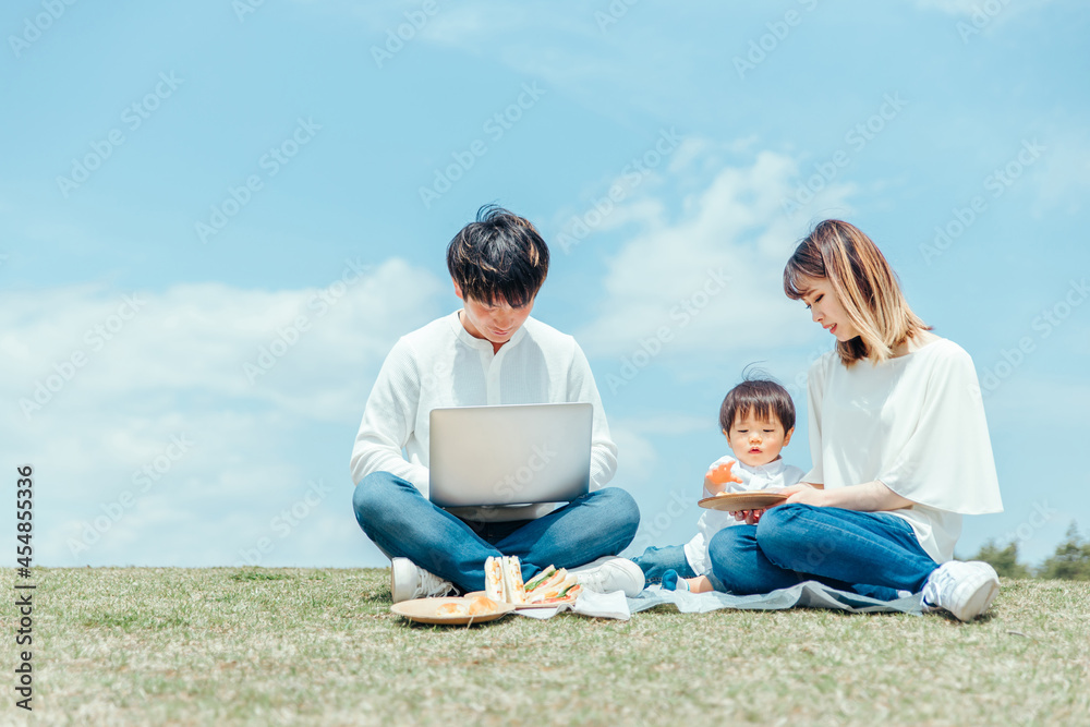 パソコンを使うパパと家族・ファミリー・赤ちゃん
