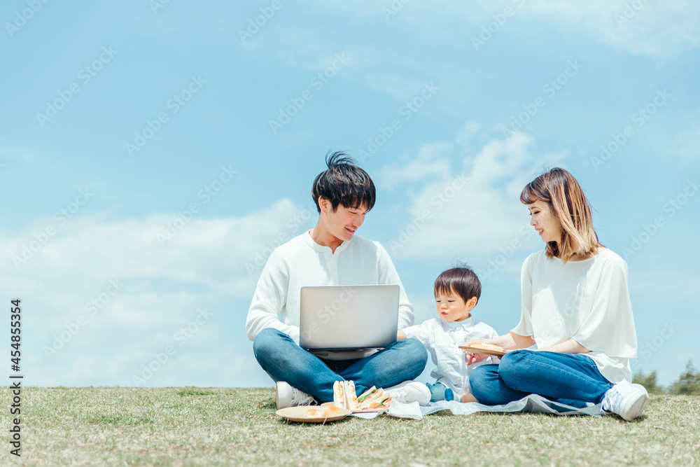 パソコンを使うパパと家族・ファミリー・赤ちゃん
