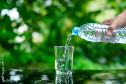 Pouring clean drinking water into the glass located on the bar.