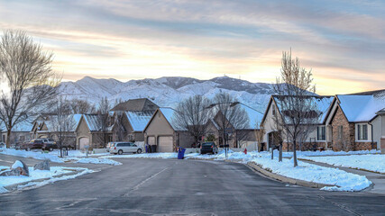 Pano Neighborhood street with road along houses overlooking mountain and cloudy sky