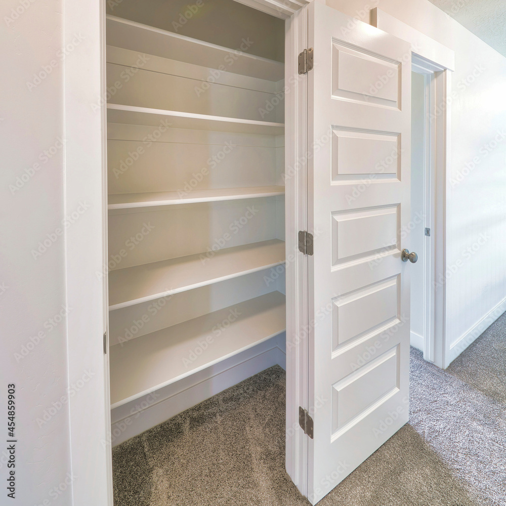 Square frame Linen closet of house with wide shelves for storing organization and white door