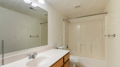 Pano Bathroom interior with long vanity sink and bathtub with shower
