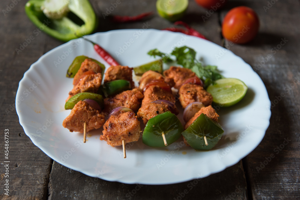 Chicken kebabs or doners grilled with saute vegetables in a white plate. Close up. Chicken kebabs or doners grilled with saute vegetables in a white plate. Close up.
