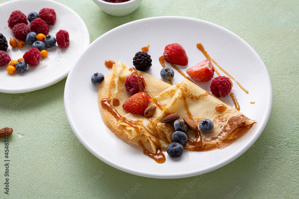 Crepes pancakes with berries on white plate food Crepes pancakes with berries on white plate food