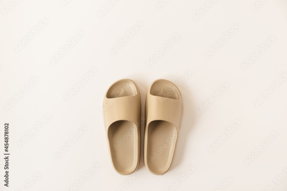 Neutral beige color summer slippers isolated on white background. Flat lay, top view minimalist fashion concept Neutral beige color summer slippers isolated on white background. Flat lay, top view minimalist fashion concept