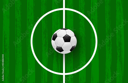 Green football field made of brush stroke with realistic soccer ball. Vector banner template for sport tournaments and competitions.