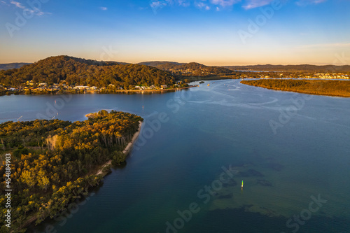 Late afternoon aerial waterscape over the bay with high clouds © Merrillie