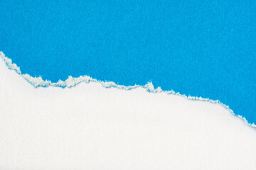 Blue paper torn to reveal white paper background