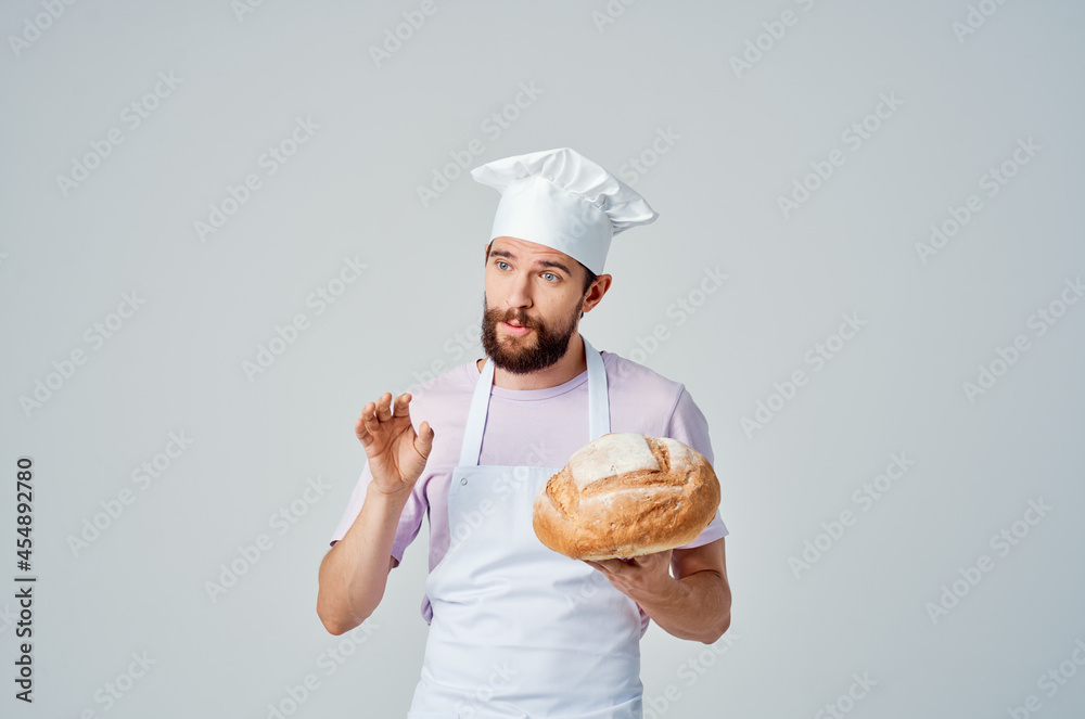 emotional Baker in a White apron with bread in his hands Professional emotional Baker in a White apron with bread in his hands Professional