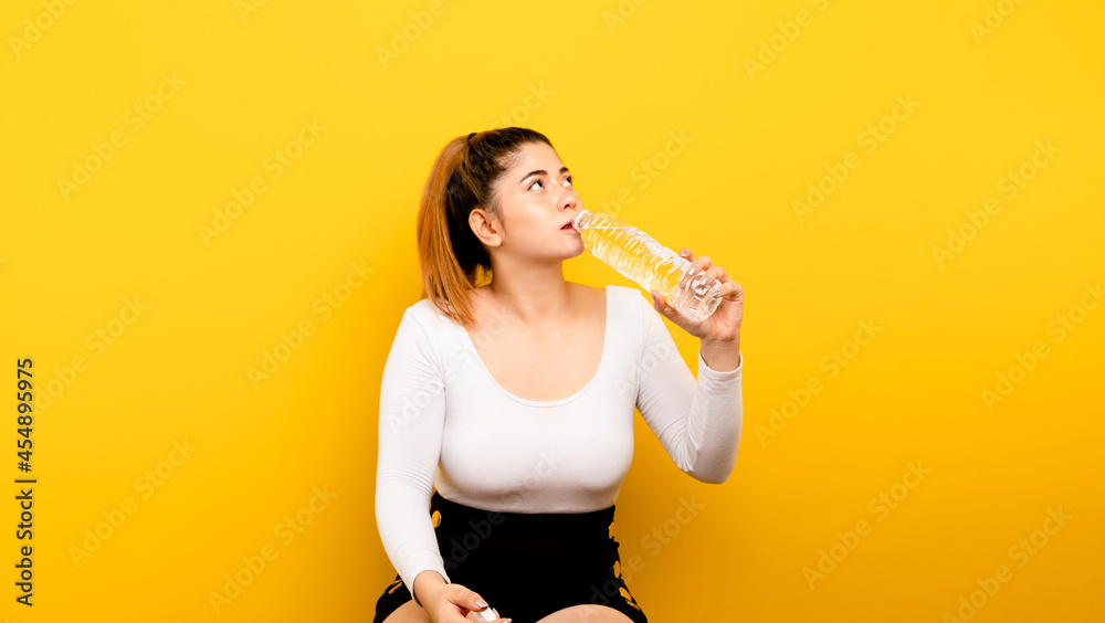 Drink clean water. Asian woman preparing to drink water. Clean from the bottle to quench thirst and to maintain a healthy drinking water concept. Drink clean water. Asian woman preparing to drink water. Clean from the bottle to quench thirst and to maintain a healthy drinking water concept.