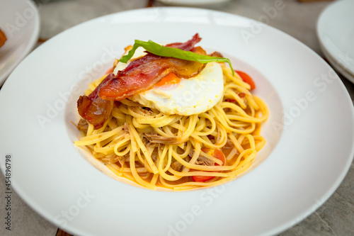 Spicy pulled pork linguine with bacon, cherry tomatoes and sunny egg on top.