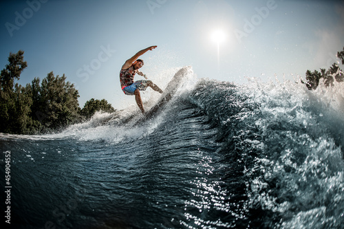 beautiful view of the great splashing wave and man balanced on it on foilboard