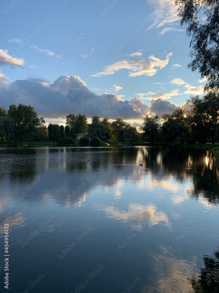 Beautiful clouds reflection on the lake surface, natural lake view background, atmosphere of peaceful evening