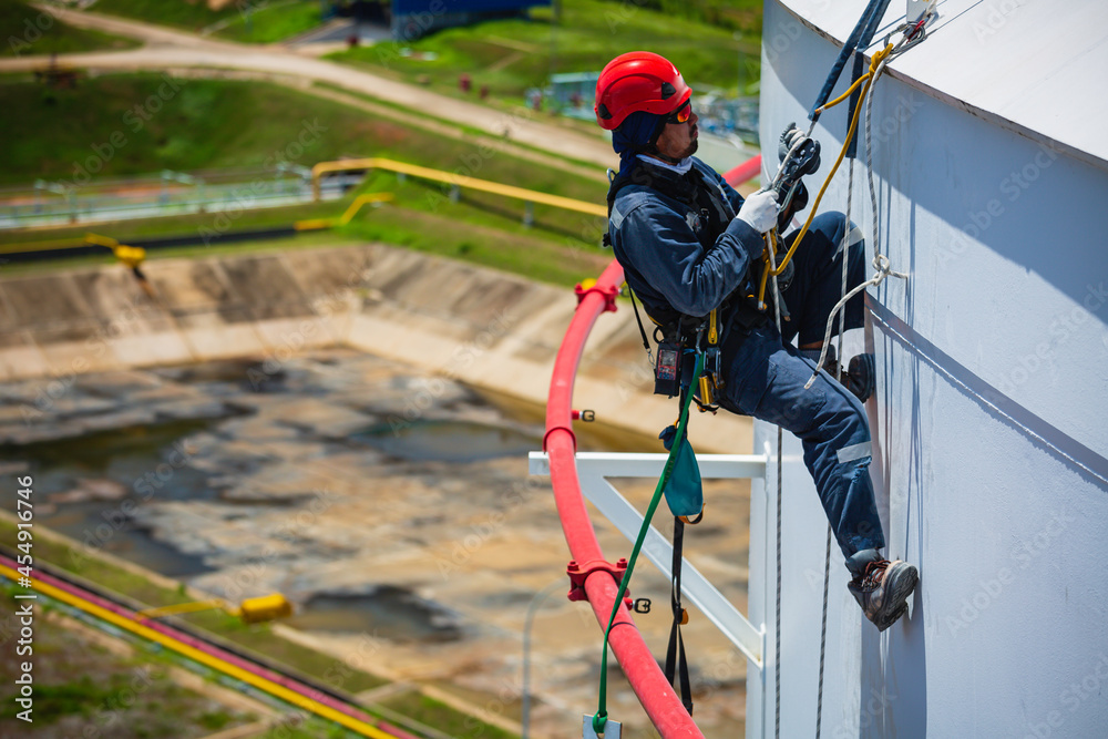 Male worker down height tank roof rope access safety inspection of thickness storage tank gas Male worker down height tank roof rope access safety inspection of thickness storage tank gas
