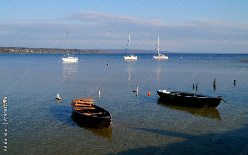 Obraz premium a scenic view of white sailing boats in the sun on lake Ammersee in Germany (Schondorf in Germany)