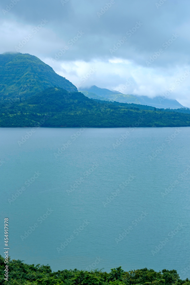 Aerial view of greenery, lake and clouds during the monsoon season at Mulshi near Pune India. Monsoon is the annual rainy season in India from June to September.