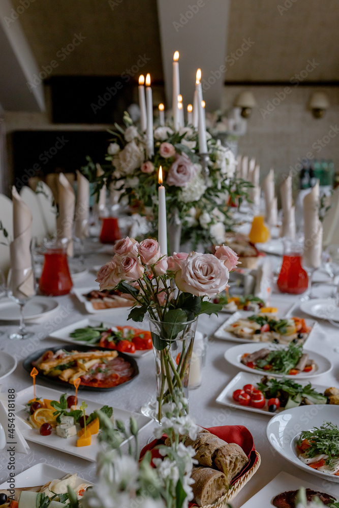 Wedding table with food and decoration for guests by candlelight