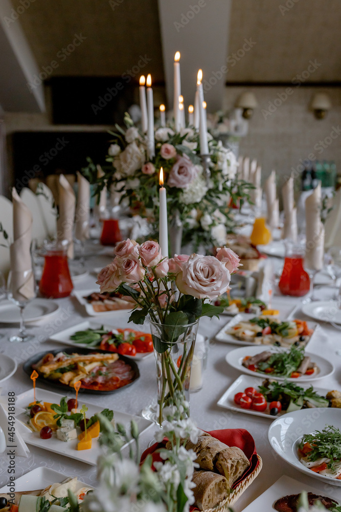 Fototapeta premium Wedding table with food and decoration for guests by candlelight