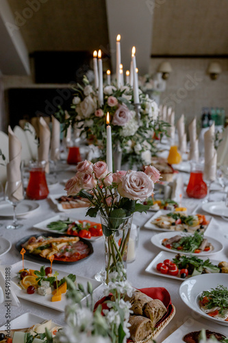 Wedding table with food and decoration for guests by candlelight
