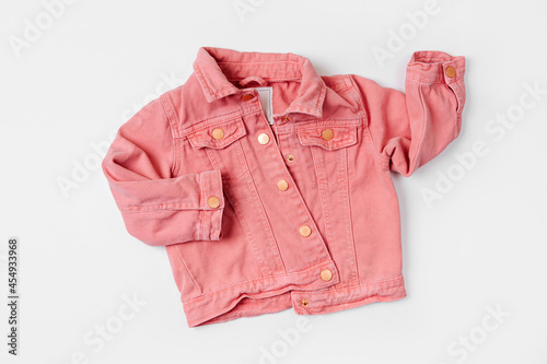 Pink jeans jacket. Baby clothes for spring, autumn or summer on  white background. Fashion kids outfit. Flat lay, top view