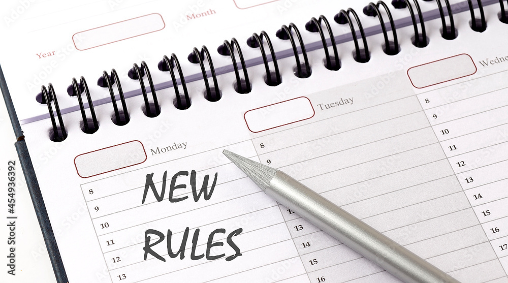 The words NEW RULES written on a calendar planner to remind The words NEW RULES written on a calendar planner to remind