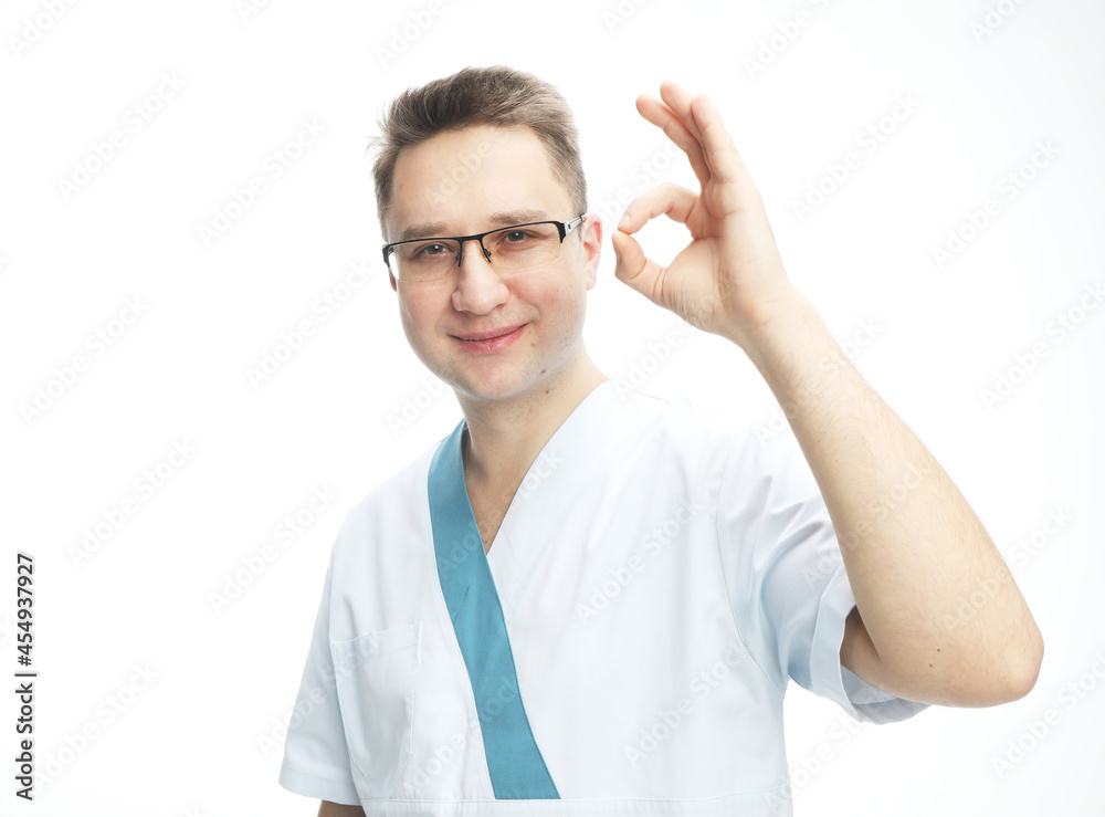 Doctor saying ok with his hand. Young male doctor wearing glasses shows ok sign, body language, medicine concept. Doctor saying ok with his hand. Young male doctor wearing glasses shows ok sign, body language, medicine concept.
