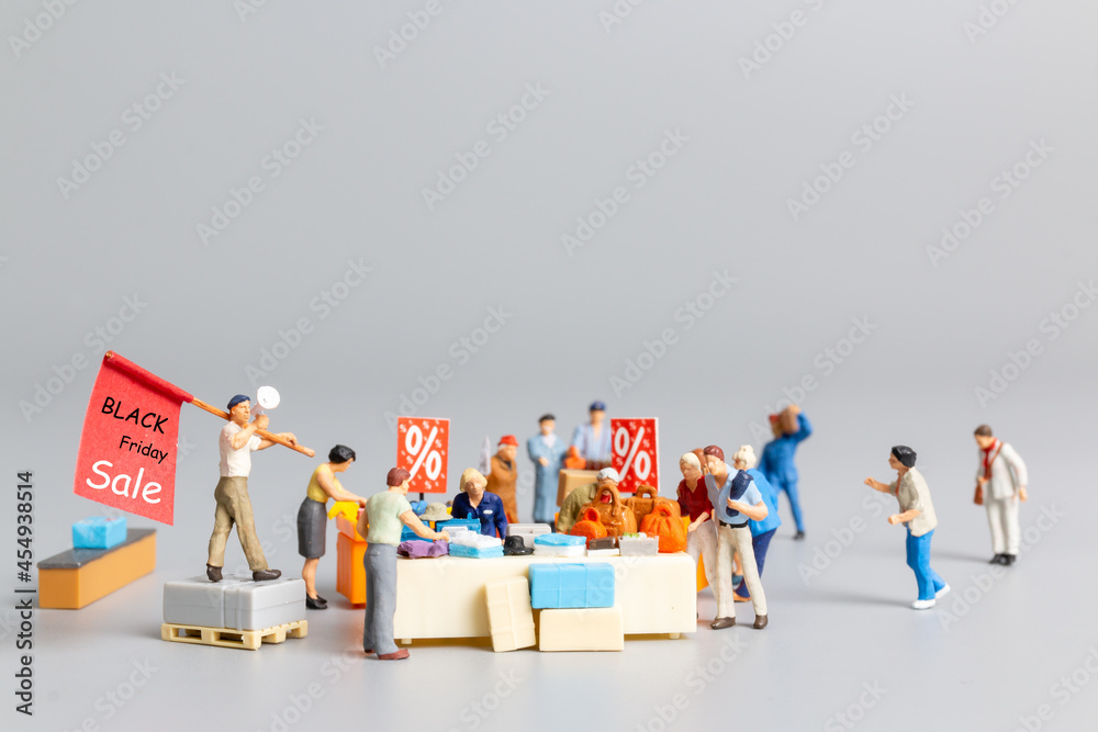 Miniature people , Shoppers with discount tray for shopping discounted items ,  Black friday concept