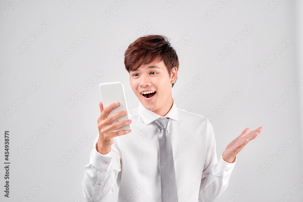 Happy Asian man using smarphone with shocked and surprised face expression Happy Asian man using smarphone with shocked and surprised face expression
