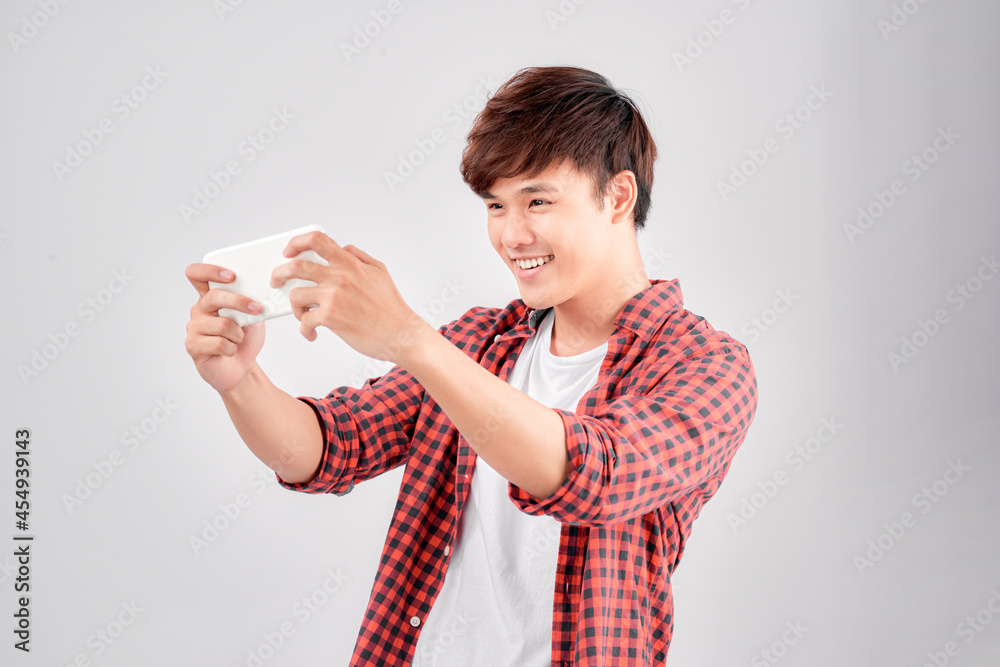 Portrait of an excited young man playing games on mobile phone Portrait of an excited young man playing games on mobile phone