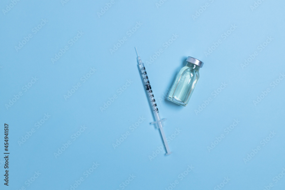 Vial with coronavirus vaccine and syringe on light blue background with copy space. Vaccination against influenza, covid 19, measles, coronavirus disease. Vial with coronavirus vaccine and syringe on light blue background with copy space. Vaccination against influenza, covid 19, measles, coronavirus disease.