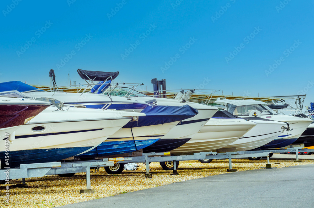 Fototapeta premium Boat on stand on the shore, close up on the part of the yacht, luxury ship, maintenance and parking place boat