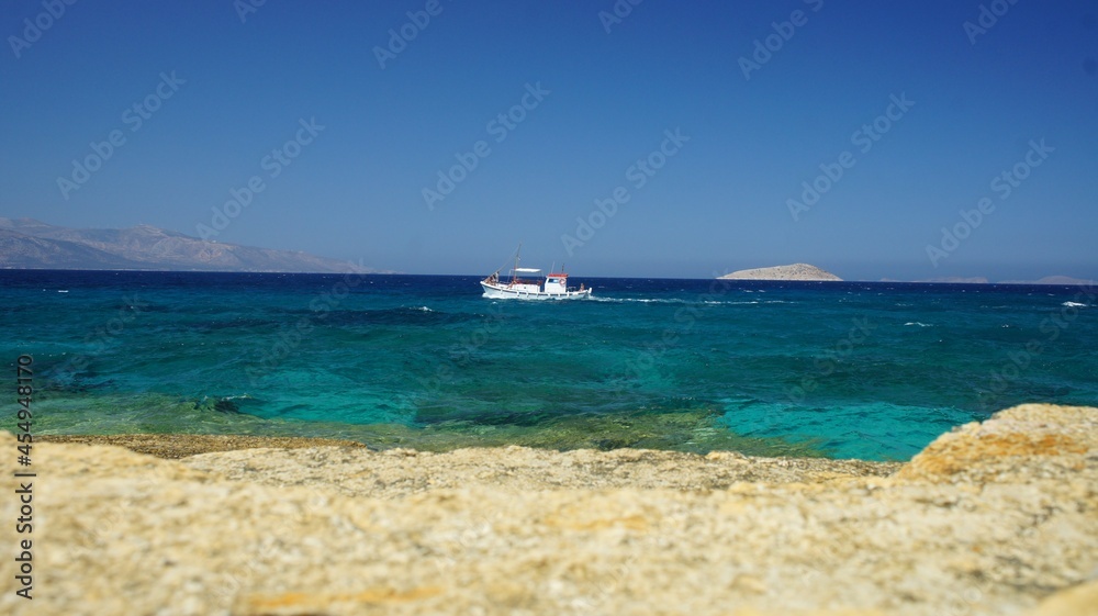 Sea and sky as a wave splash appears on the cliff in the Greek island of koufonisi August 2021 Sea and sky as a wave splash appears on the cliff in the Greek island of koufonisi August 2021