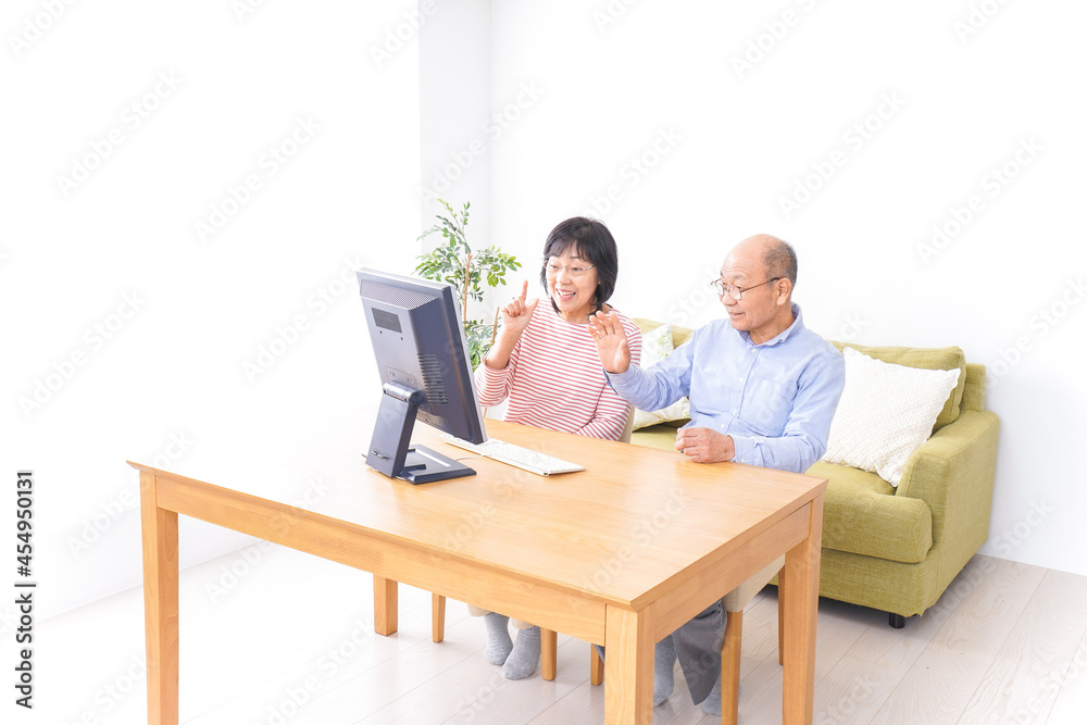 パソコンでテレビ電話をする高齢の夫婦 パソコンでテレビ電話をする高齢の夫婦