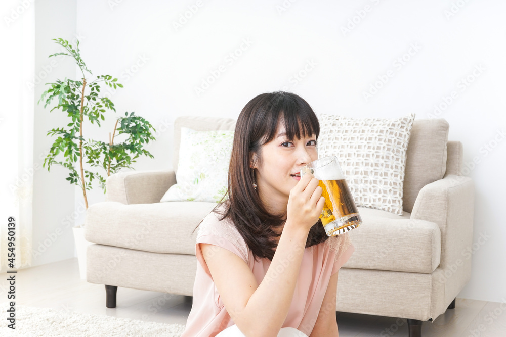 自宅でビールを飲む若い女性