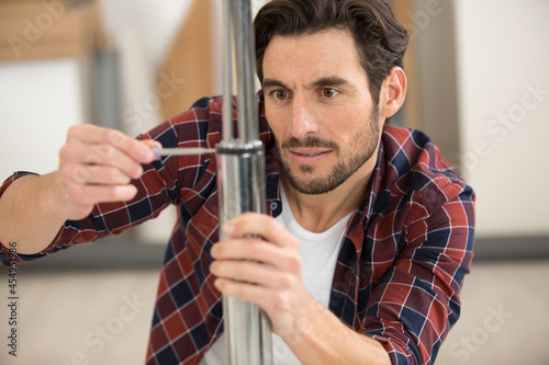 man using screwdriver to locate rubber seal into groove photo