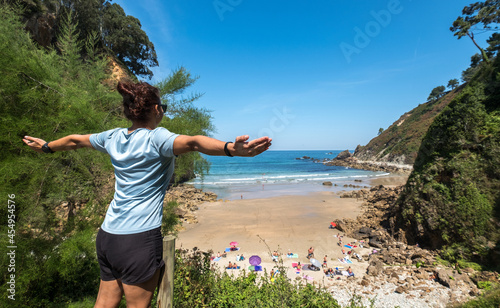 girl with outstretched arms at the end of the beach viewpoints path, Senda de los Miradores Aguilar Asturias Muros del Nalon Spain, adventure tourism
