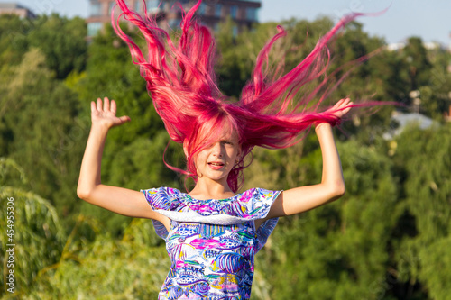 Girl with red hair on a sunny summer day. Glamorous pink hair