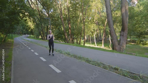 Wallpaper Mural Blond slender strong woman caucasian lady runner athlete in black tracksuit runs marathon speed distance cardio exercise workout jogging running jog in park outdoors makes effort work on body weight Torontodigital.ca