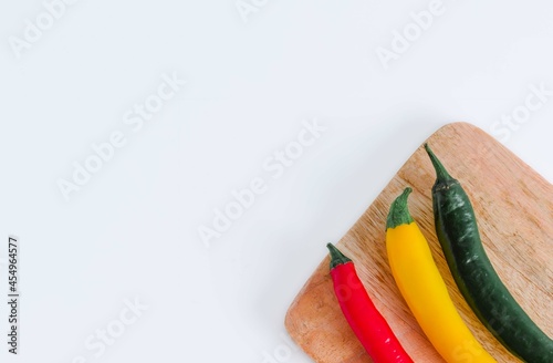 Close up of hot peppers isolated on white background.Red, yellow and green hot peppers. On a wooden table.