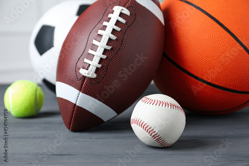 Set of different sport balls on grey wooden table  closeup